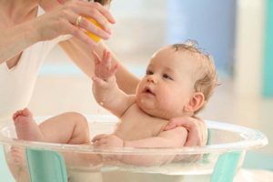 tắm thường xuyên để tránh trẻ bị nổi mề đay ở mặt